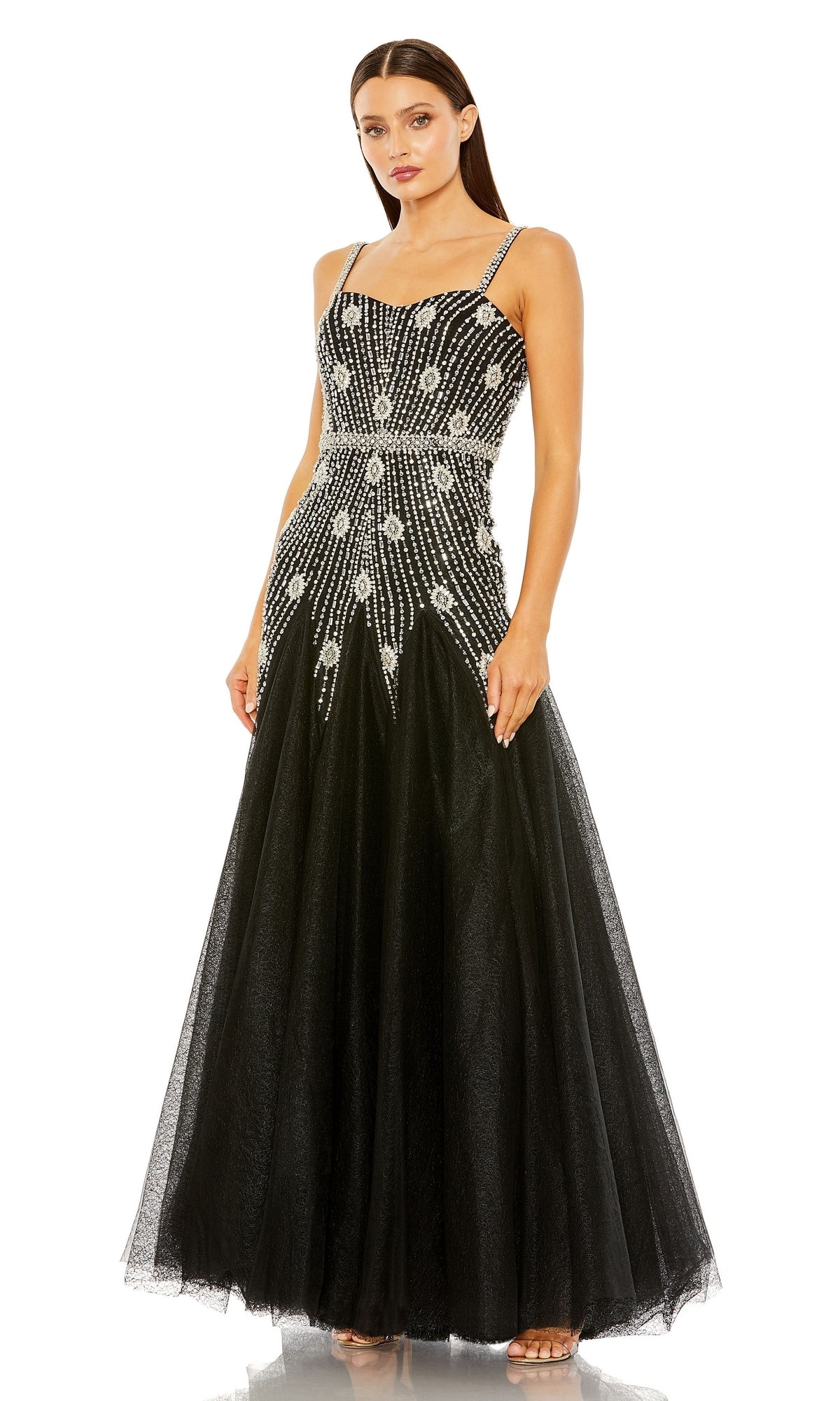 A woman models the Long Formal Dress 2236 by Mac Duggal—an elegant black A-line gown with silver sequin embellishments and thin straps—against a white background.